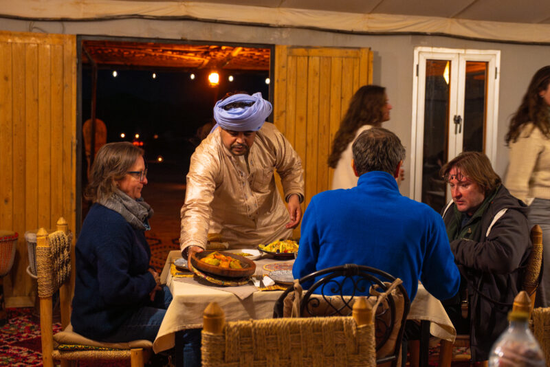 Guests dining at a desert camp in Morocco
